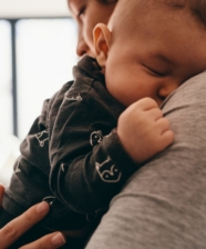 a woman holding a baby as he sleeps